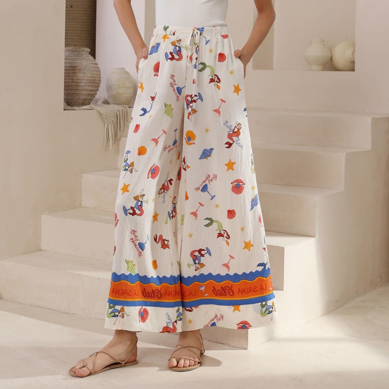 Our Mermaid Party Palazzo Pants have a fun resort inspired print with a white base.