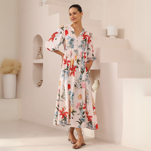 Shelby Maxi Dress - it features a lovely floral print in pink, red and blue tones against a dusty pink base.