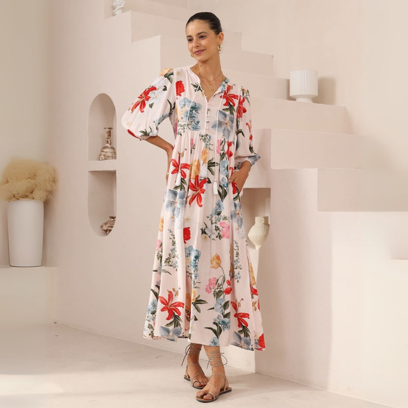 Shelby Maxi Dress - it features a lovely floral print in pink, red and blue tones against a dusty pink base.
