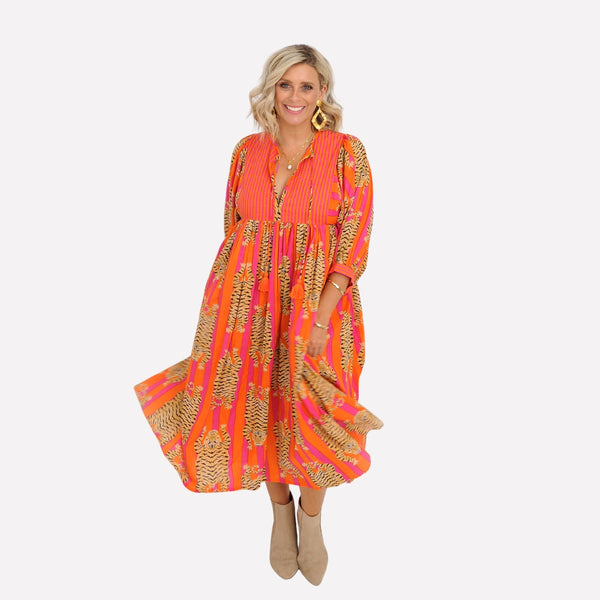 The dress has a round neckline with V opening, half length sleeves and a full midi length skirt.