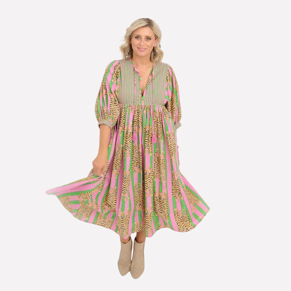 The dress has a round neckline with V cut-out and neck ties, half length sleeves and a full  midi skirt.