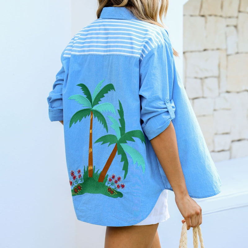 Back view of the shirt - it has a contrast blue and white stripe panel across the upper back and a large embroidered palm print on the back.