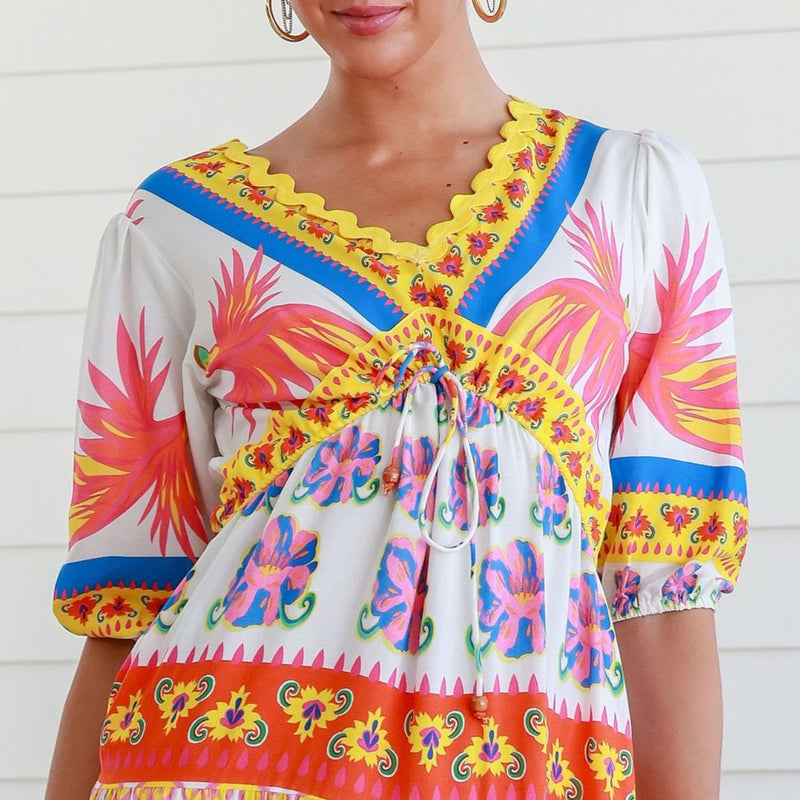 Close up of the bodice with yellow ric rac detailing around the neckline and it features a V shape under the bust with drawstring ties