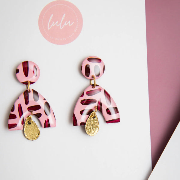 Arch shape earring suspended from a single stud with a gold metallic teardrop accent.