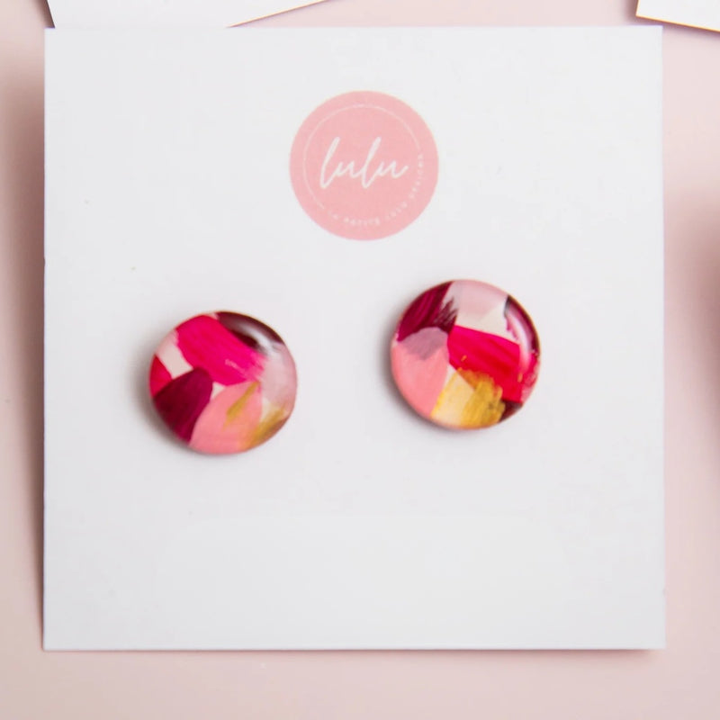 Pair of round earrings with pink and gold design. These Mulled Horizon Stud Earrings are lightweight and handmade.