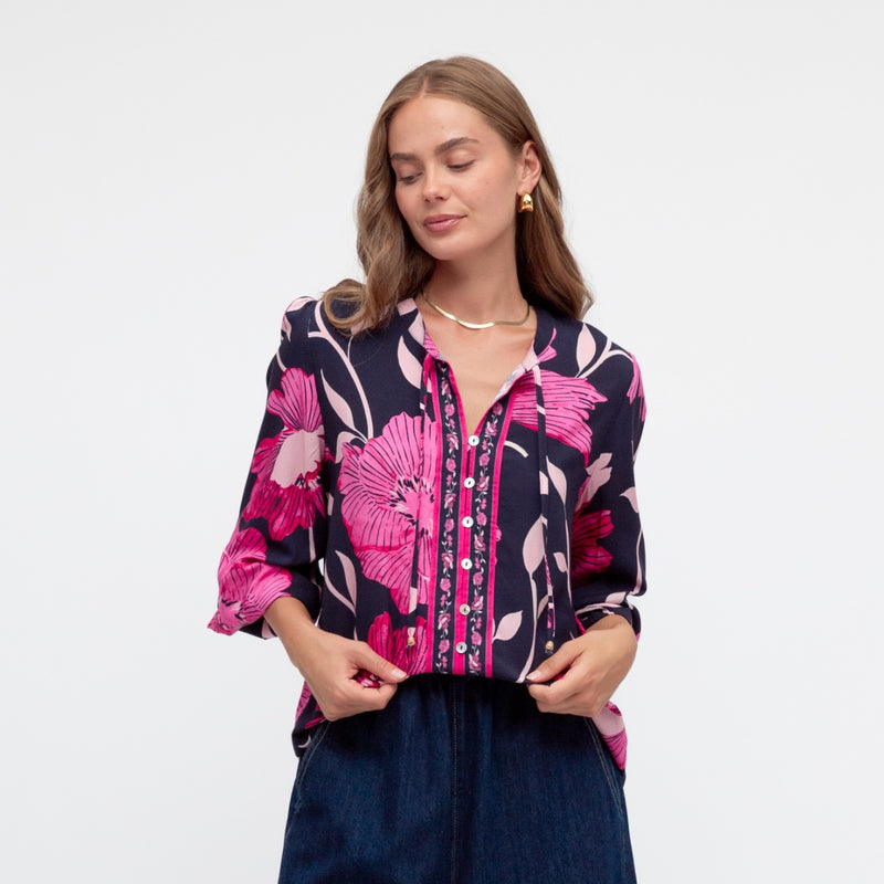 Features a round neckline, neck ties and a button front.