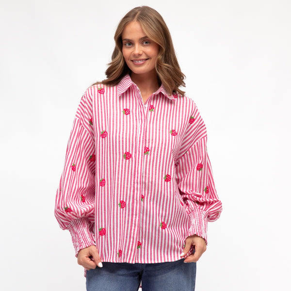Model wearing the Strawberry Stripe Shirt with pink and white stripes.  The shirt also has strawberries embroidered on it.