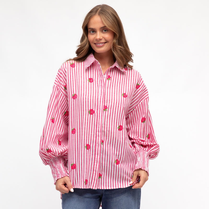 Model wearing the Strawberry Stripe Shirt with pink and white stripes.  The shirt also has strawberries embroidered on it.