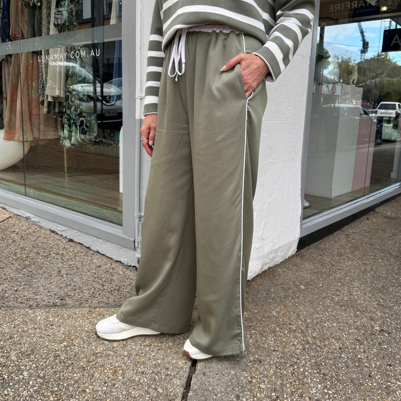 Side view of the pants - they have pockets and a thin white side stripe down the outer leg.
