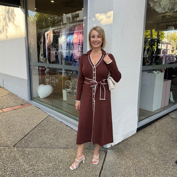 This polo style dress has a collar, V neckline, button detailing on the front, long sleeves and an Aline midi skirt.