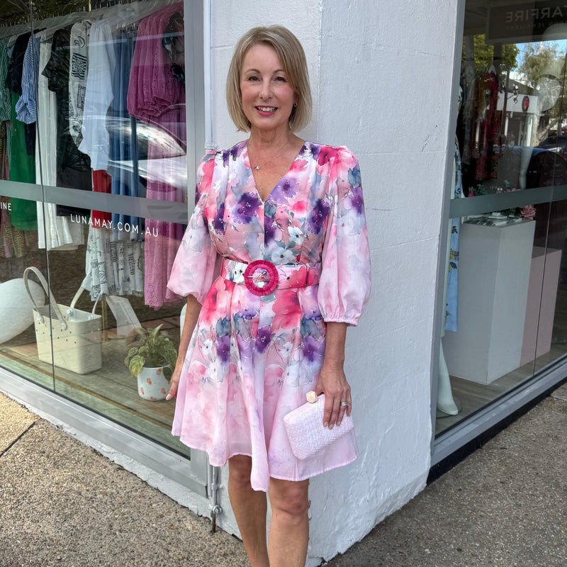 The dress can be accessorised with a pink clutch.
