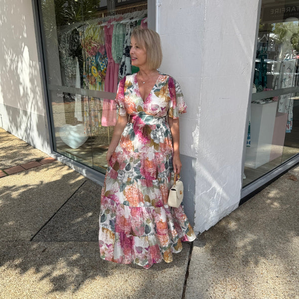 This maxi dress has a V neckline, flutter sleeves and a tiered skirt.