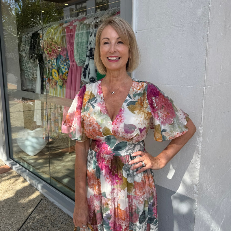 Close up of the bodice area - it has a V neckline, flutter sleeves and a peak panel under the bust.