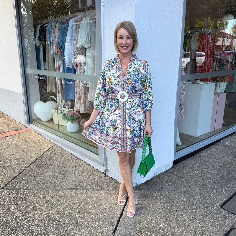 The dress sits above the knee and can be accessorised with a green bag and heels.