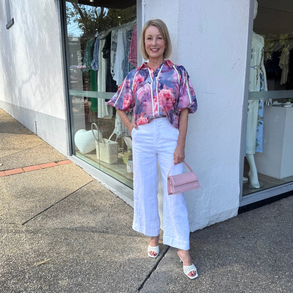 The shirt can be paired with our white Nisha pants and a pink bag.