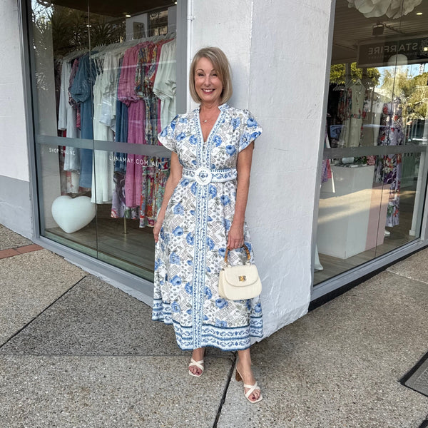 This dress has a mock collar, V neckline, button front, cap sleeves and a detachable self print belt.