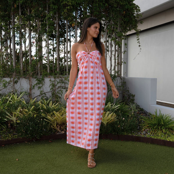 The dress has a halter neckline, fitted bodice and a full maxi length skirt.