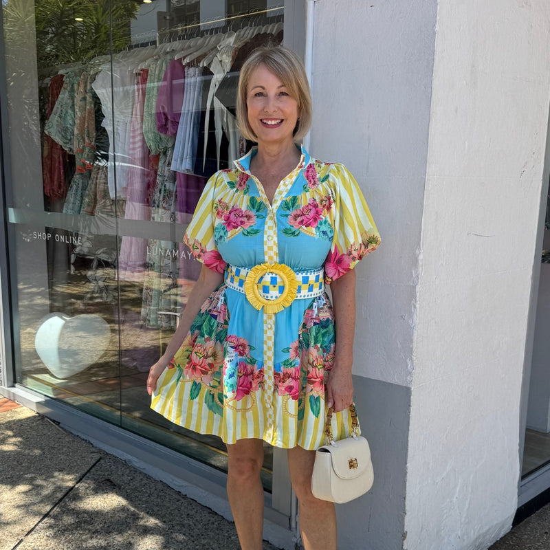 This colourful dress has a mock collar, button front, short puff sleeves and a statement belt with yellow raffia buckle.