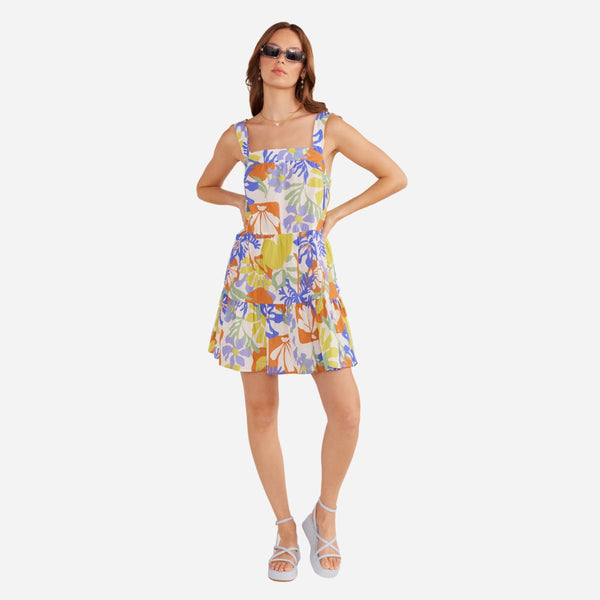 Our Dahlia Mini Dress has a fun tropical print in white, green, yellow, blue and a burnt orange.