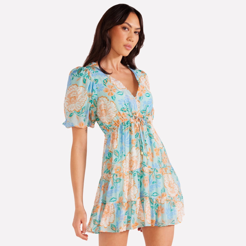 This lovely dress has a floral print and features a V neckline, short puff sleeves and drawstring ties under the bust
