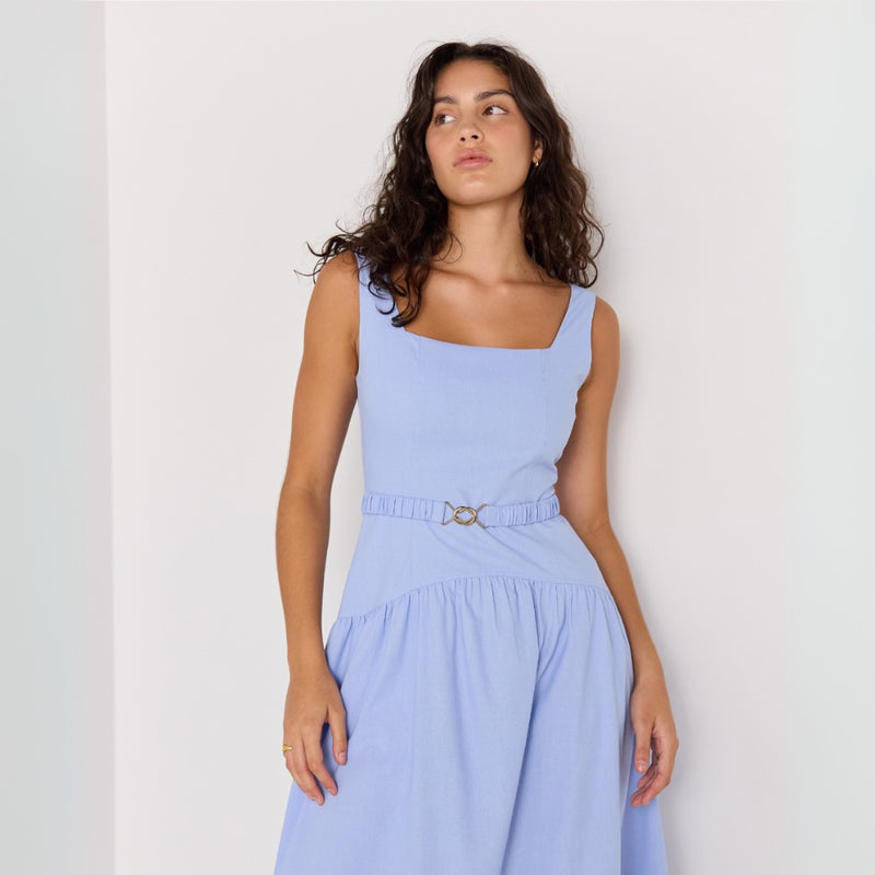 Close up of the bodice area - featuring a square neckline, wide shoulder straps, elasticated belt with gold buckle and a curved gathered detail along the hips.