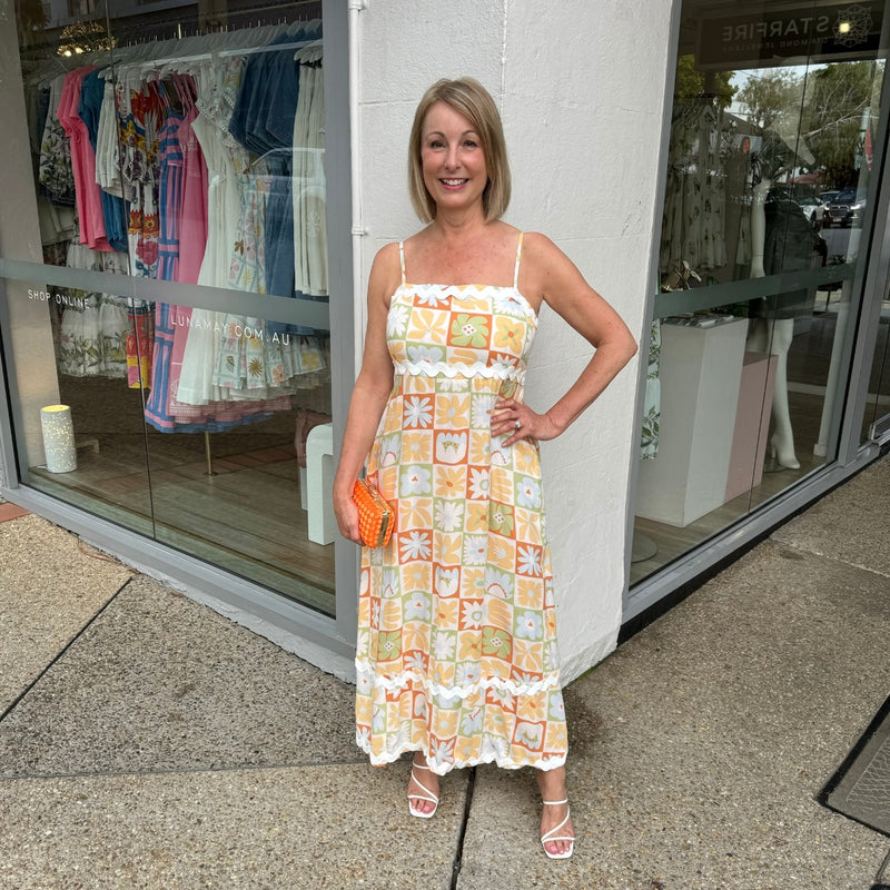 Add a pop of colour with an orange clutch and white heels