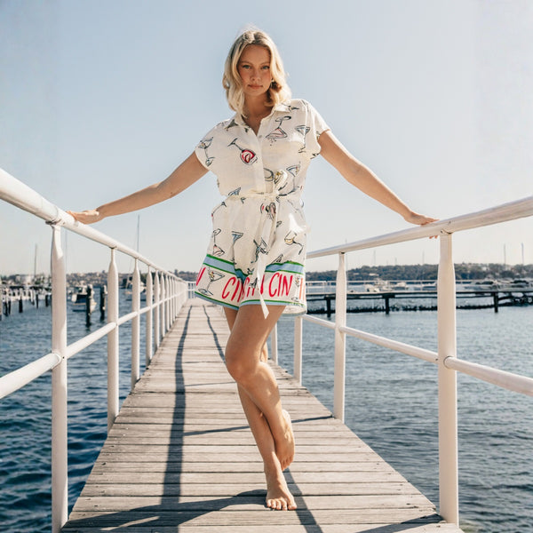 This playsuit is all manner of fun - it has a collar, button front, short sleeves and it has Cin Cin along the hem of the shorts.