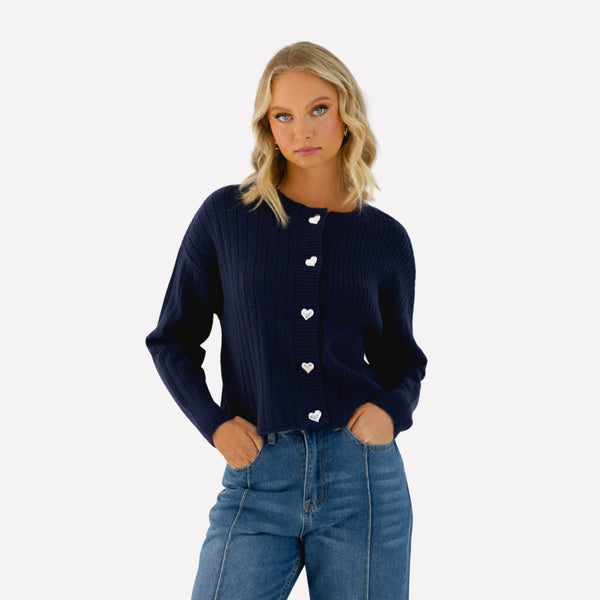 The cardigan features a round neckline, drop shoulder, long sleeves and silver heart buttons down the front.