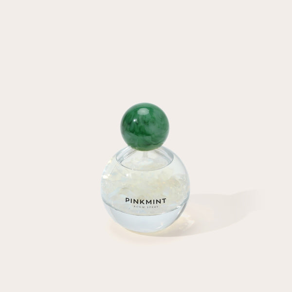 The room spray bottle has a green cap.