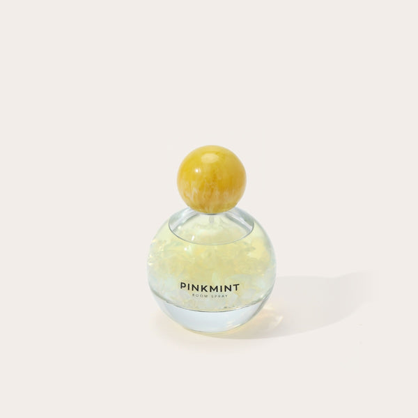 Pink Mint room spray bottle with a yellow cap.