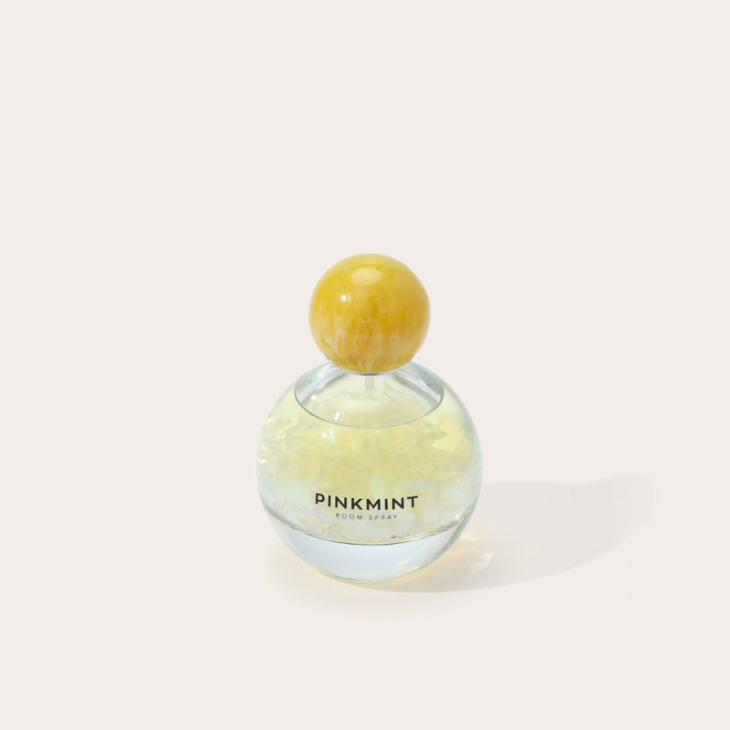 Pink Mint room spray bottle with a yellow cap.