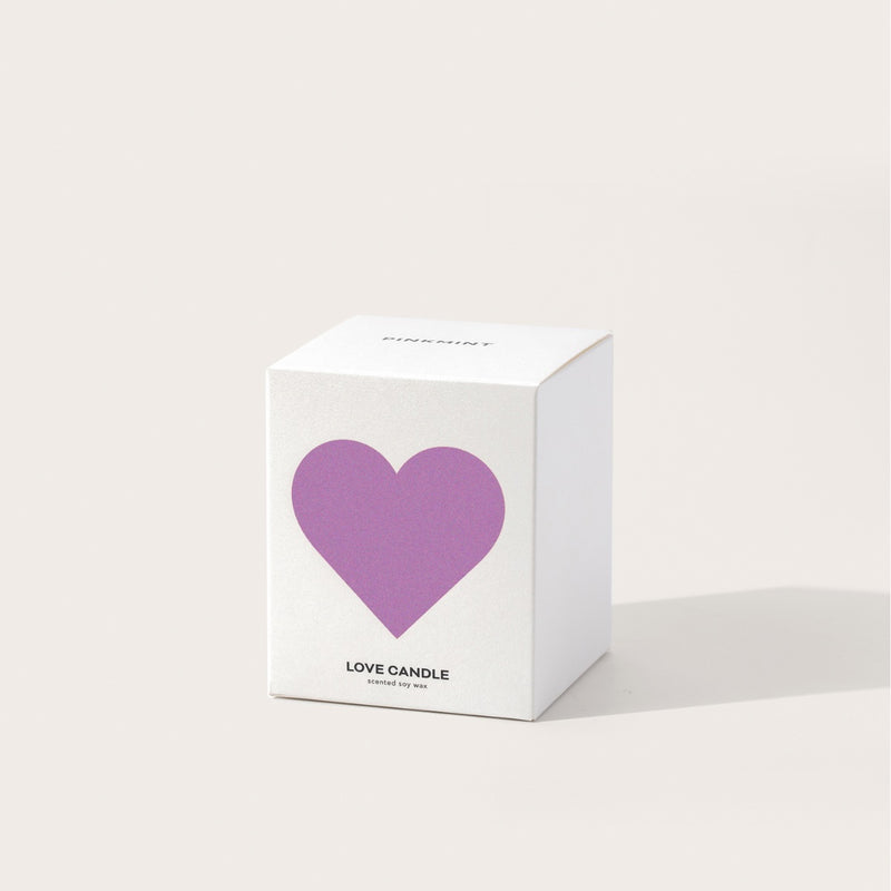 This candle is packaged in a white box with a lilac coloured heart on the front.