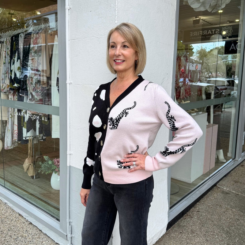 Side view of the cardigan - it has a V neckline, button front, long sleeves and a ribbed hem.