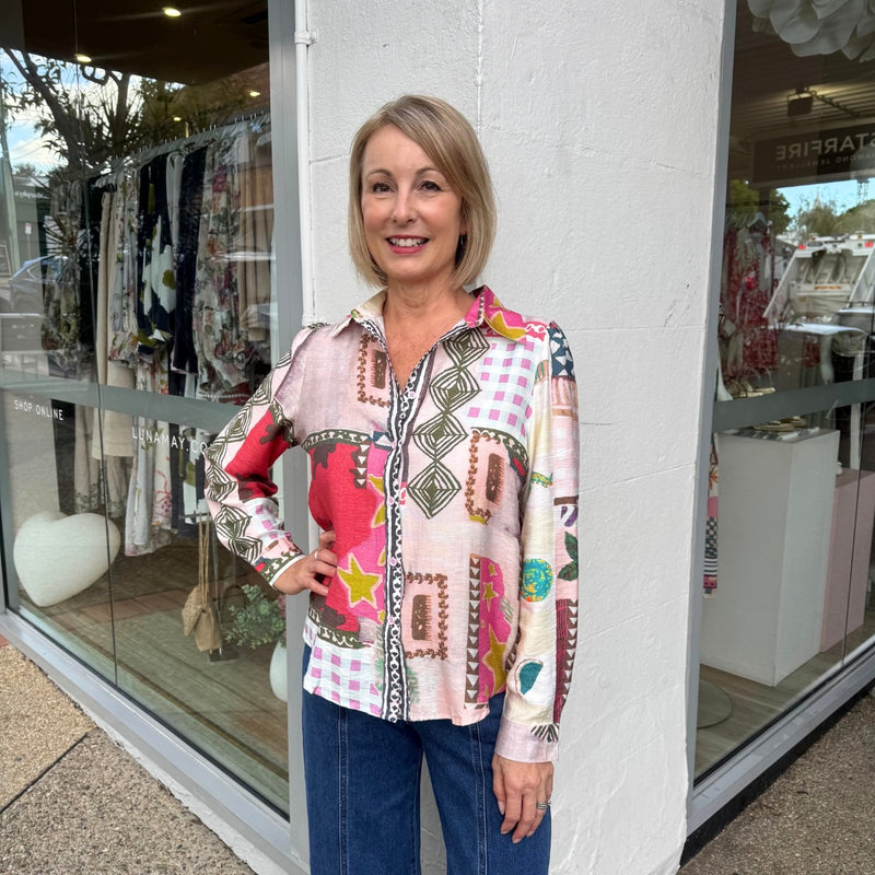 The shirt has a curved hemline and can be worn loose over pants or jeans.