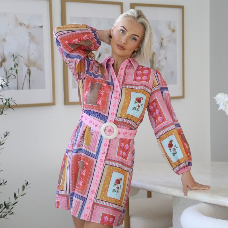 Our Adina Patchwork Shirt Dress has a lovely pink multi-coloured print. Features a collar, long sleeves with elasticated cuffs, button front, detachable belt and it has a contrast print on the belt, collar, button front.