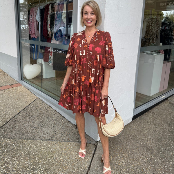 Our Ember Tiered Dress is available in a gorgeous tropical inspired print with brown, cream, orange and pink tones.