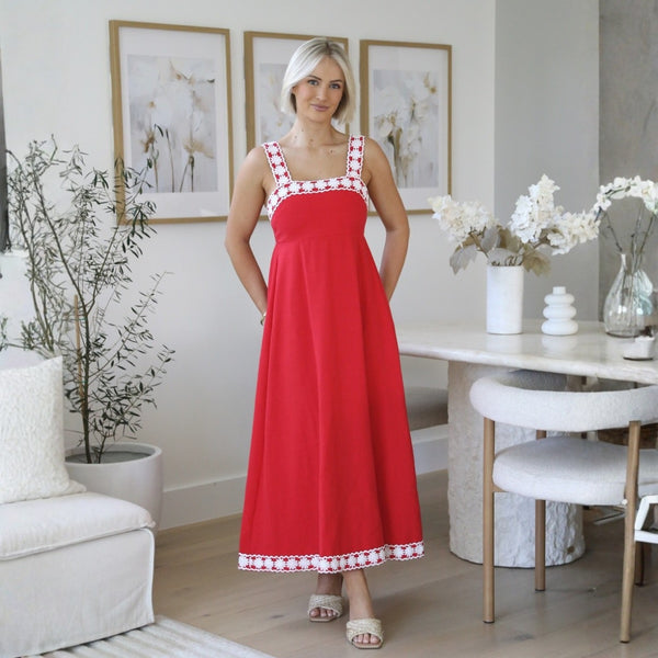 Model wearing our Faith Embroidered Maxi Dress in red with white crochet detailing on the neckline and hem.