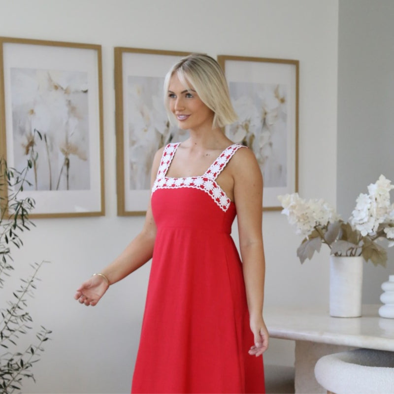 Close up of the white crochet detailing extending along the neckline and shoulder straps.