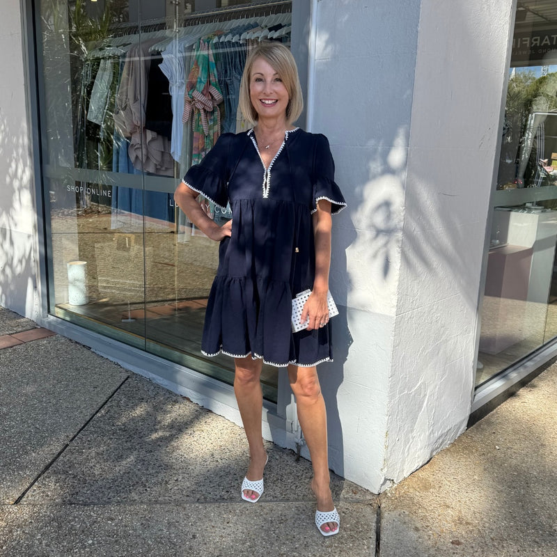 Our Renee Tiered Dress is available in navy with contrast white stitching.