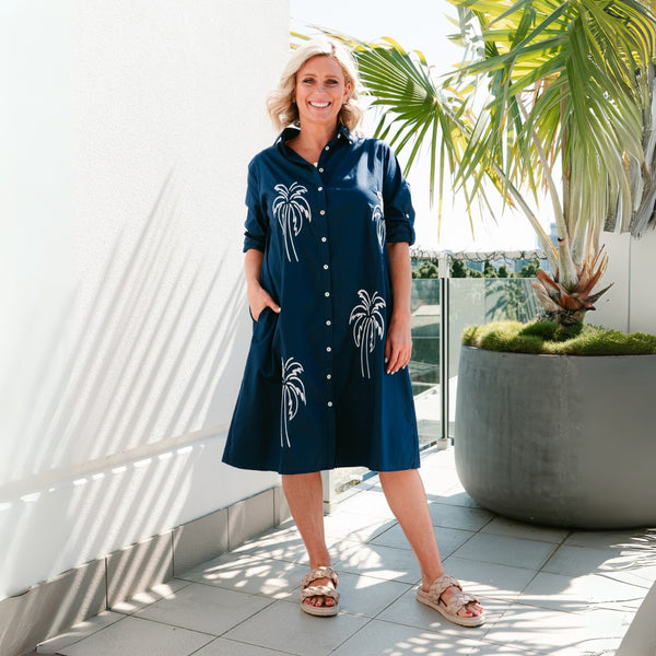 Sunset Palm Shirt Dress in navy with white embroidered palm trees on the front.