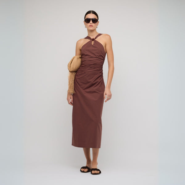 This dress features a cross-over detail on the neckline, fitted throughout the body with gathered detailing along the waist.