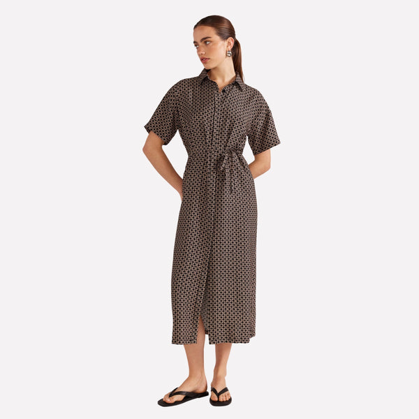 Our Lexi Shirt Dress has a geo print in black and taupe. It features a button front, short sleeves and midi length skirt