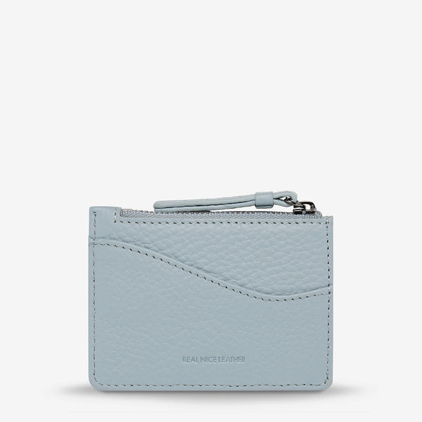 This powder blue wallet has a zip closure and external compartment on the back.
