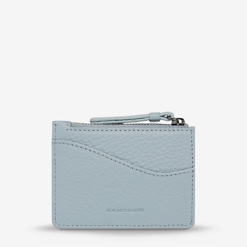 This powder blue wallet has a zip closure and external compartment on the back.