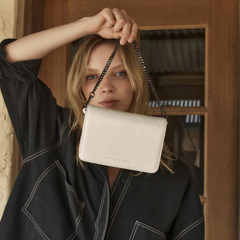 Model carrying the bag with the shoulder chain.