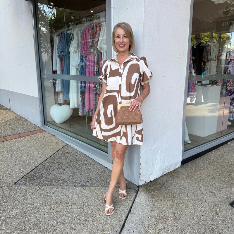 This short dress has a collar, button front, short sleeves and an Aline body.