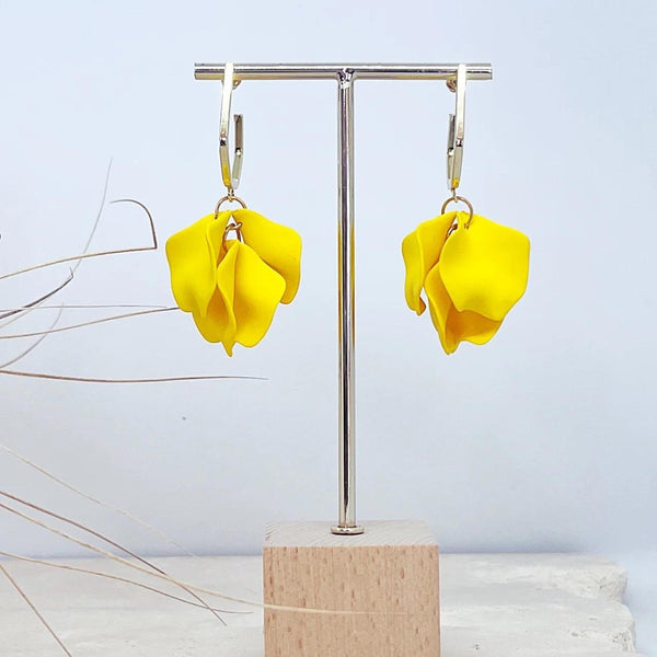 These earrings have yellow petals suspended from a gold hexagonal hoop