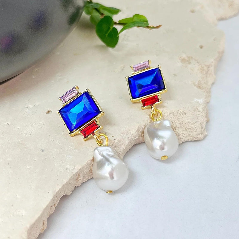 These earrings have a small pink stone, larger blue stone, small red stone and a faux pearl drop