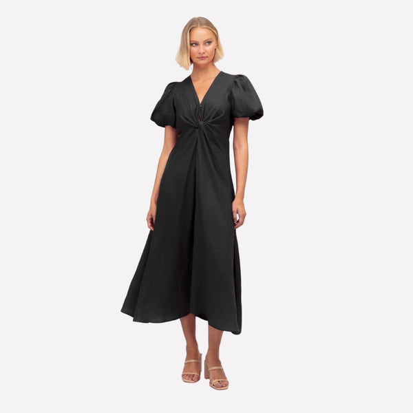 Mae Twist Linen Dress in black. This dress has a V neckline, twist detail on the bodice, short puff sleeves and an Aline midi length skirt