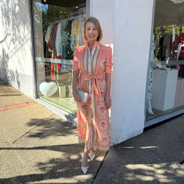 Our Acacia Dress has a beautiful resort inspired print in cantaloupe (peach), cream and green tones. 